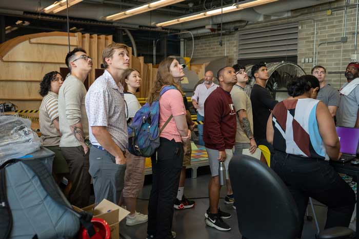 About 10 people tour an MIT aerospace building