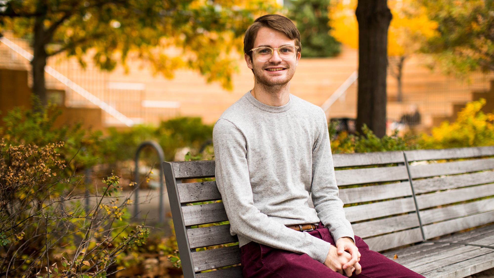 Kevin Costello sitting on a bench on MIT Campus, by Adam Glanzman