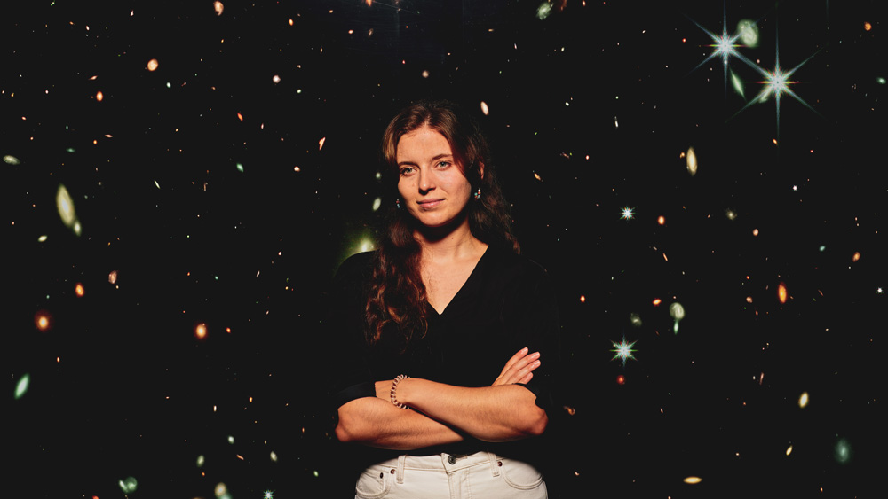 Dominika Ďurovčíková stands in front of a giant image of a galaxy