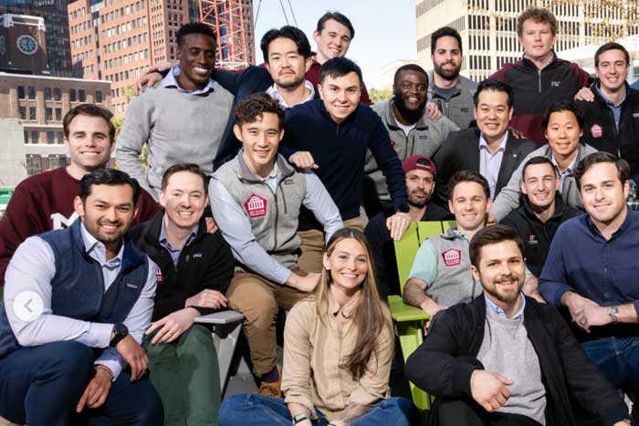 About 20 people pose for a group photo outside