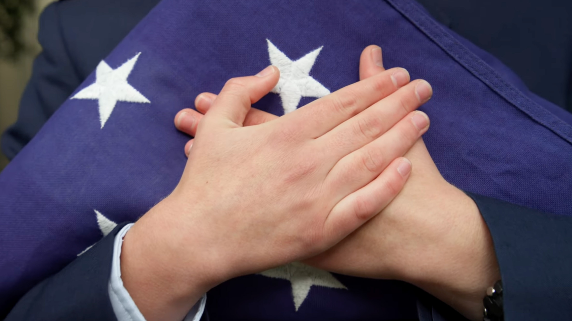 An MIT cadet's hands holding the American flag